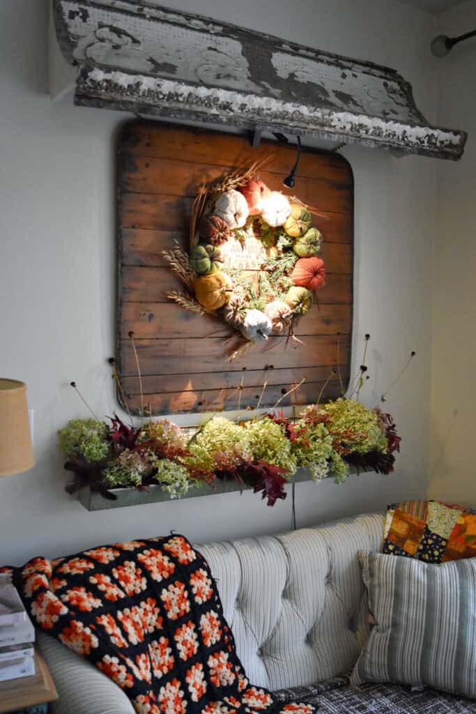 Vintage metal tin awning and autumn pumpkin wreath as Fall decor.