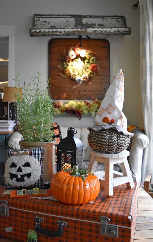 Pumpkins on a plaid suitcase Fall coffee table display.