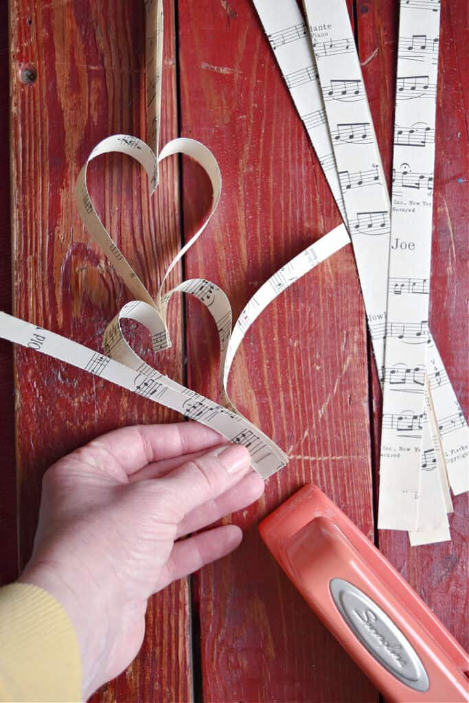 Crafting DIY paper heart garland with vintage music.
