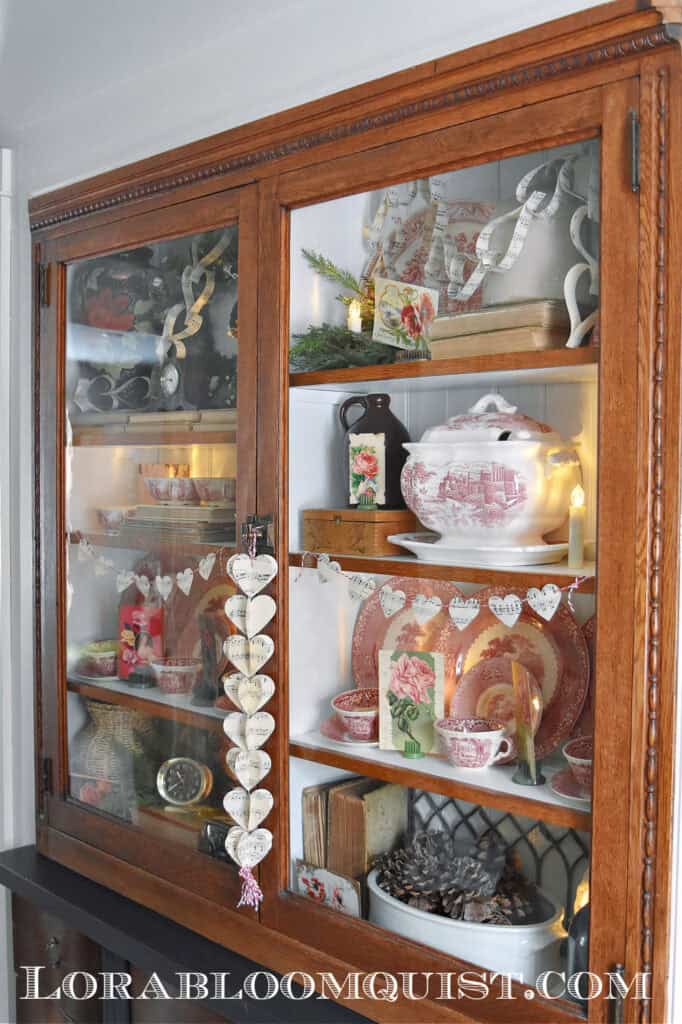 Vintage Valentines Decorations in glass front antique bookshelf.