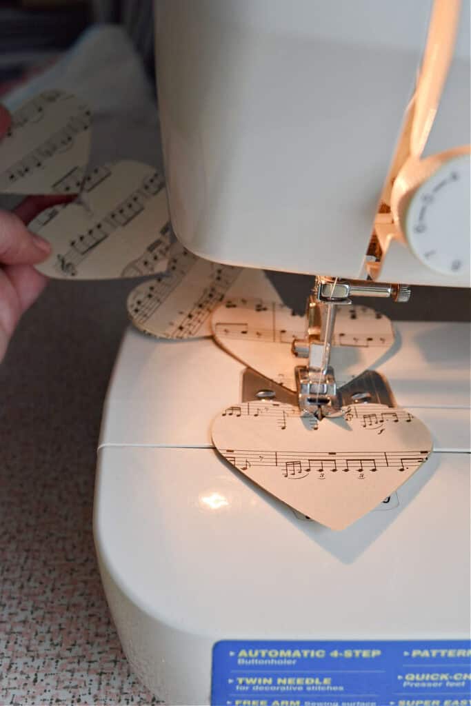Crafting DIY paper heart garland with vintage music.