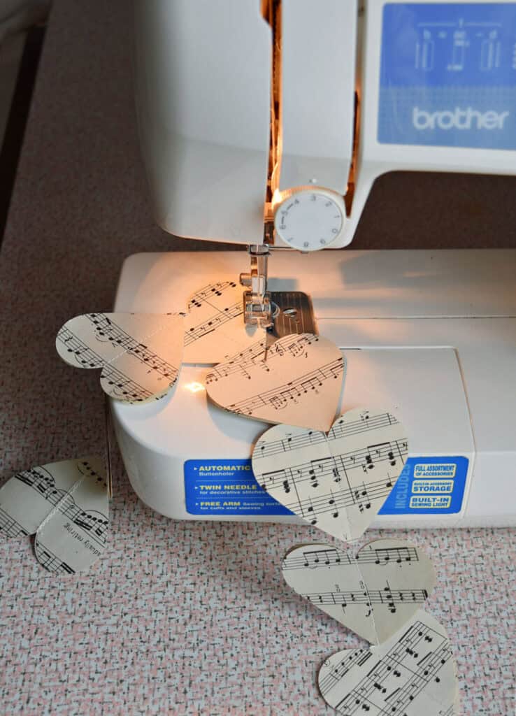 Crafting DIY paper heart garland with vintage music.