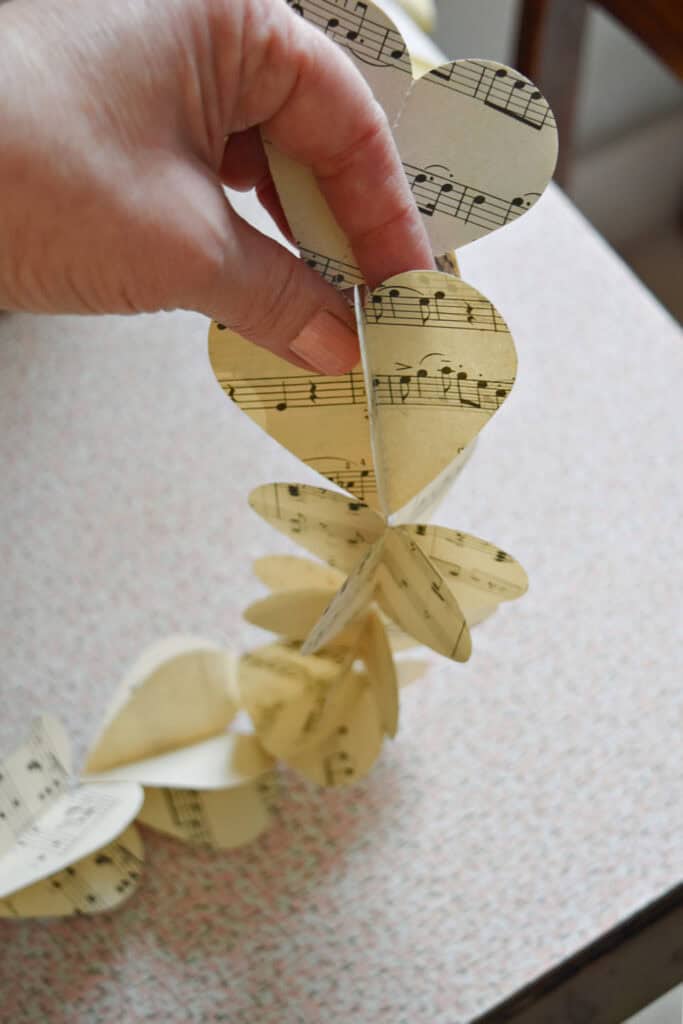 Crafting DIY paper heart garland with vintage music.