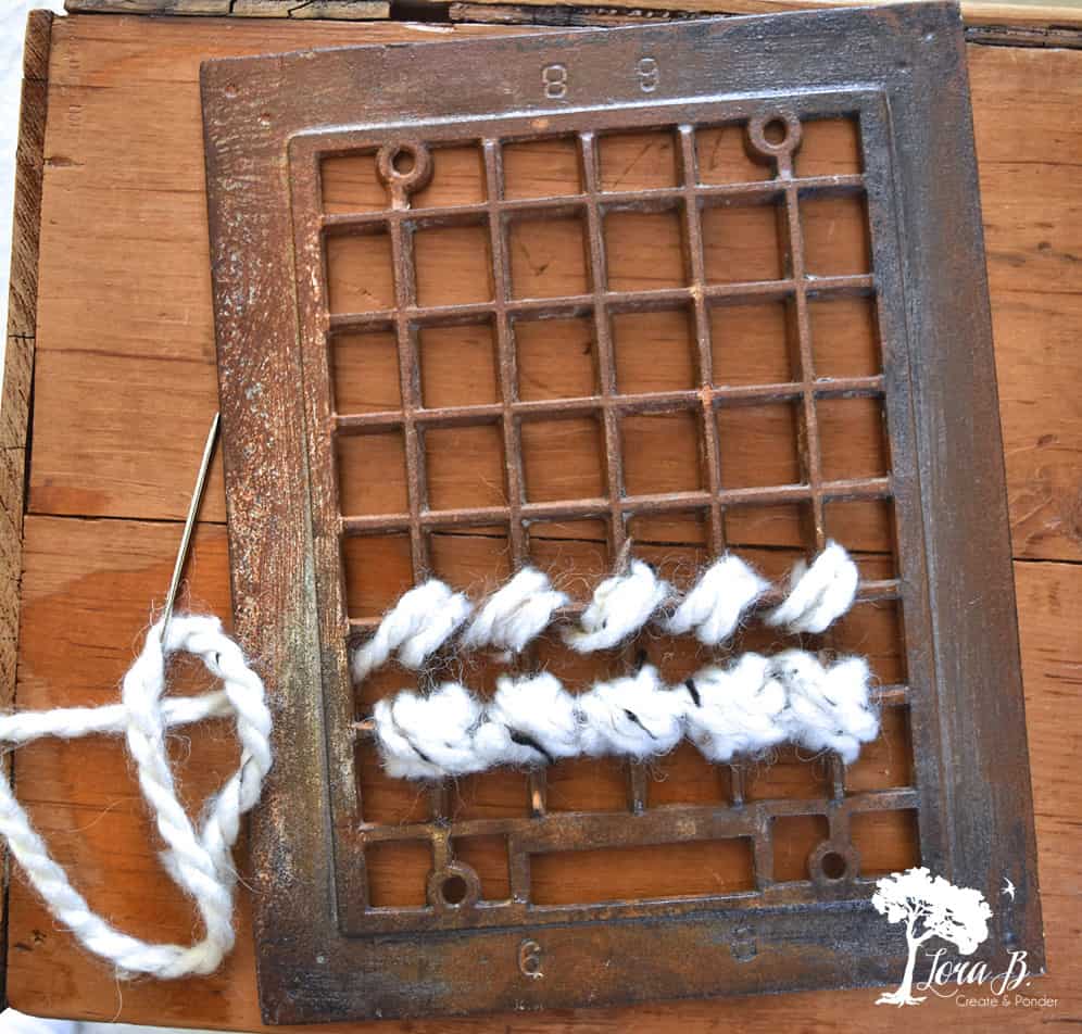 DIY yarn art on old heat grate as Christmas decor