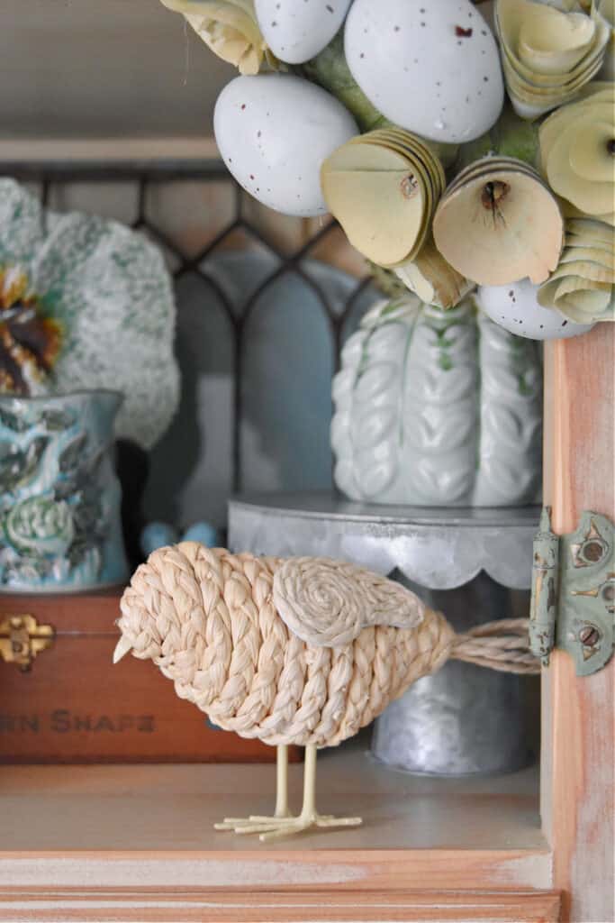 Woven bird figurine in Spring decorated hutch.