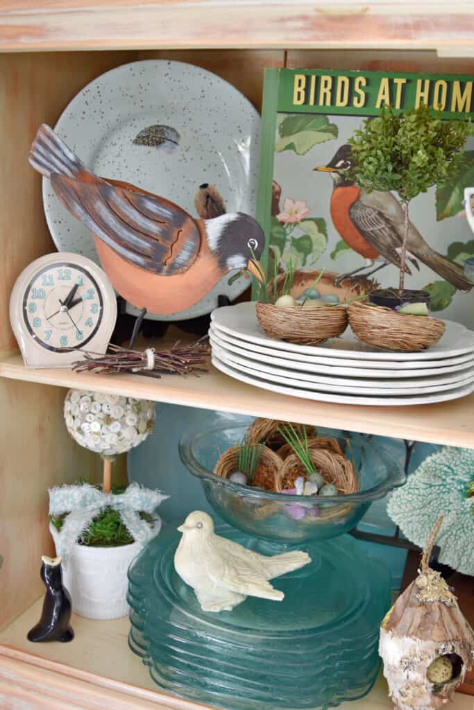 Spring hutch decor with vintage dishes and birds.