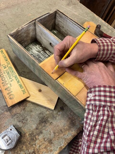 Putting cheese box graphics on back of cabinet.