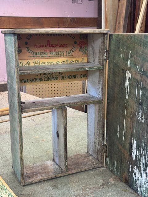 Putting cheese box graphics on back of cabinet.