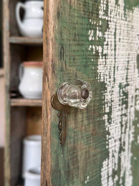 Vintage glass knob with old key behind.