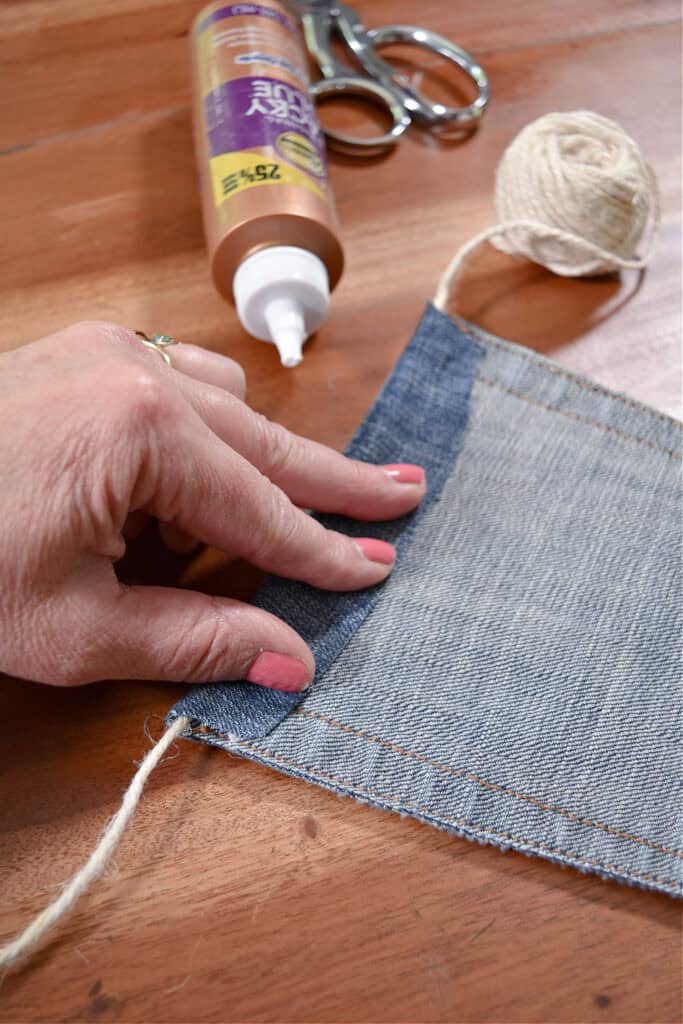 Crafting jean pocket garland with tacky glue.