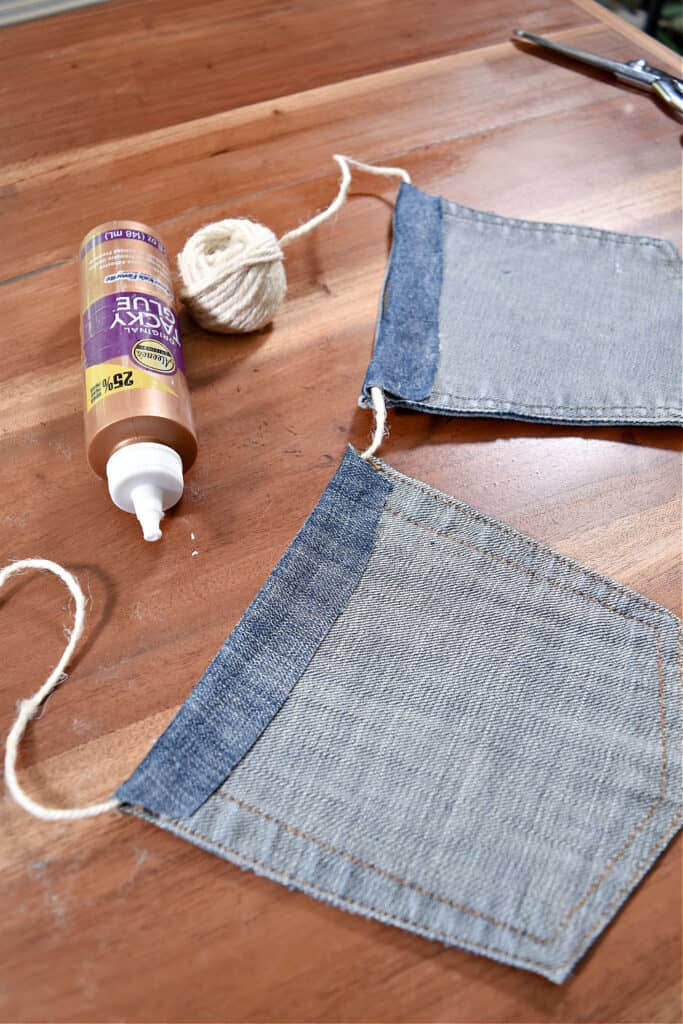 Crafting jean pocket garland with tacky glue.