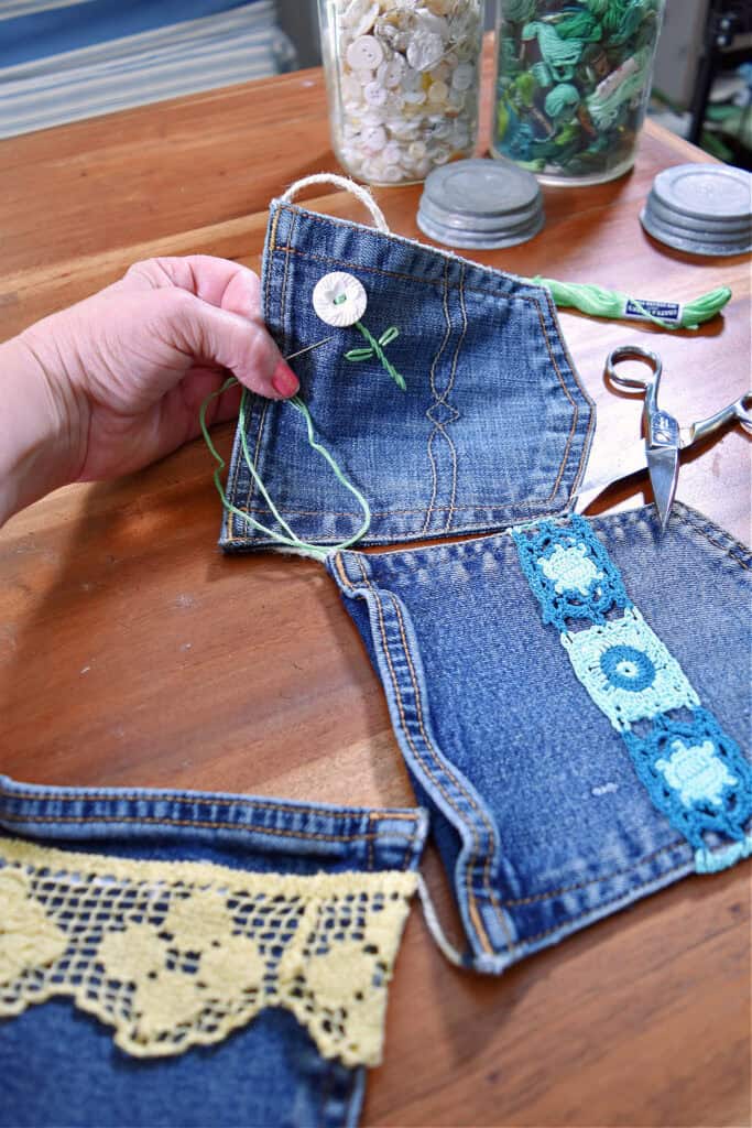 Embroidered button flower on jean pocket garland.