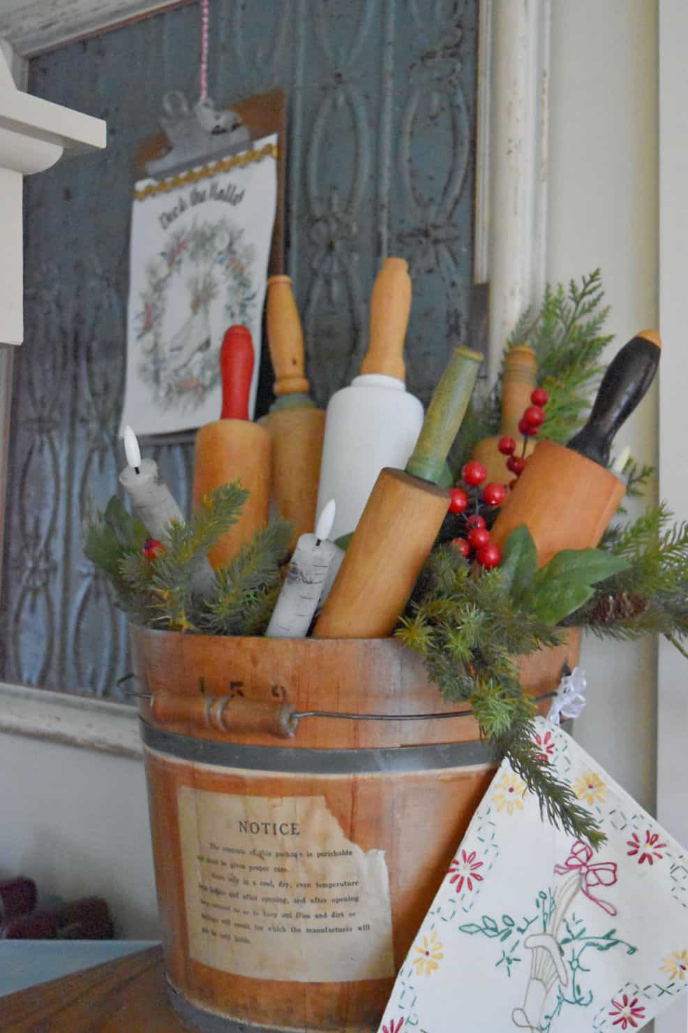 Vintage rolling pins in wooden bucket as Christmas decor.