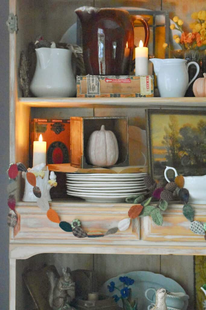 Fall hutch display with scrap fabric leafy garland.