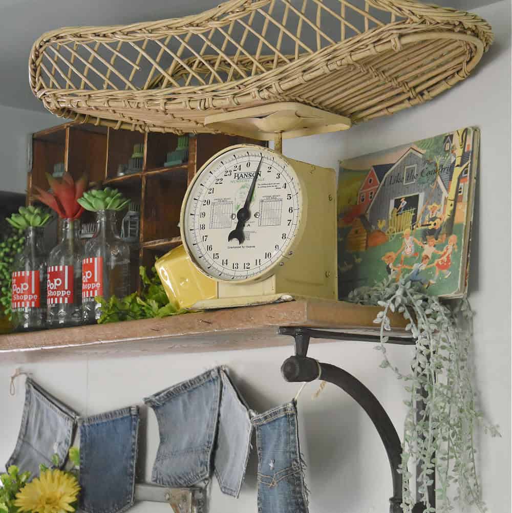 Vintage baby scale with wicker top on shelf.