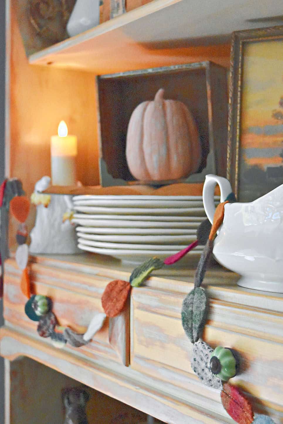Scrap fabric leafy garland hung on fall hutch display.