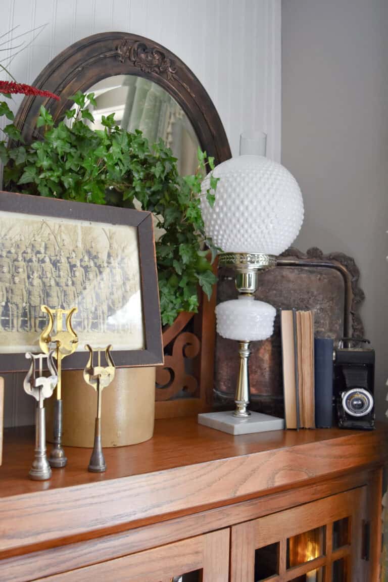 Vintage white hobnail lamp on bookshelf with vintage Patriotic finds.