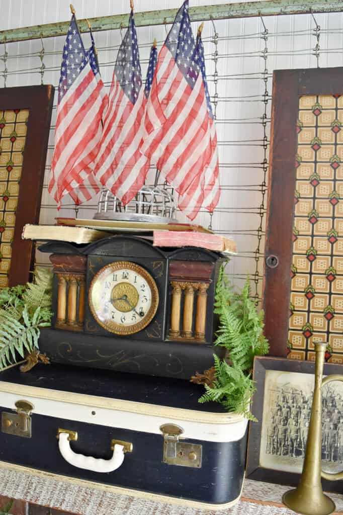 Antique clock and American flags on mantel.