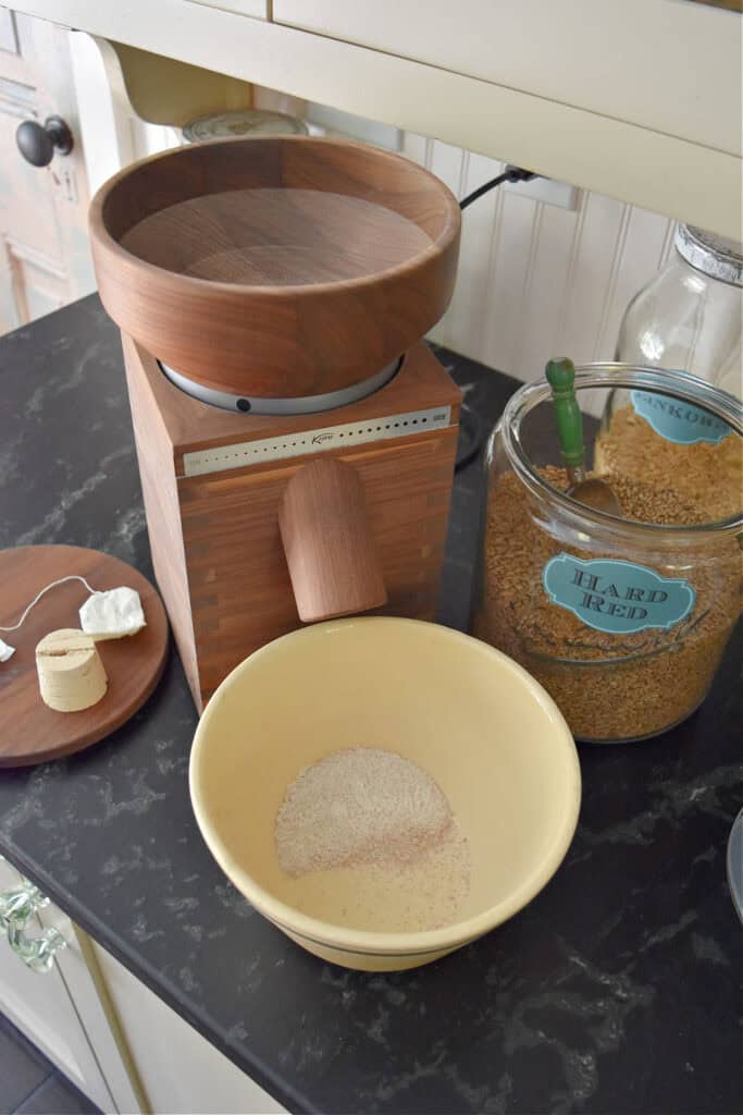 Wooden grain mill making freshly milled flour.