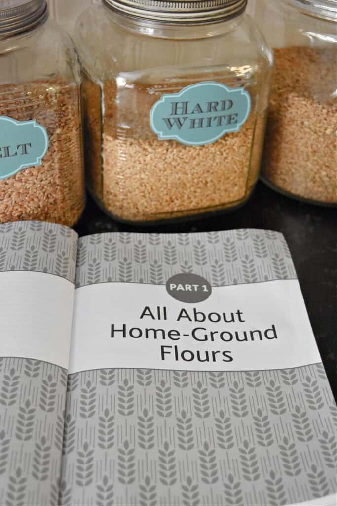 Cookbook open and grains in glass jars.