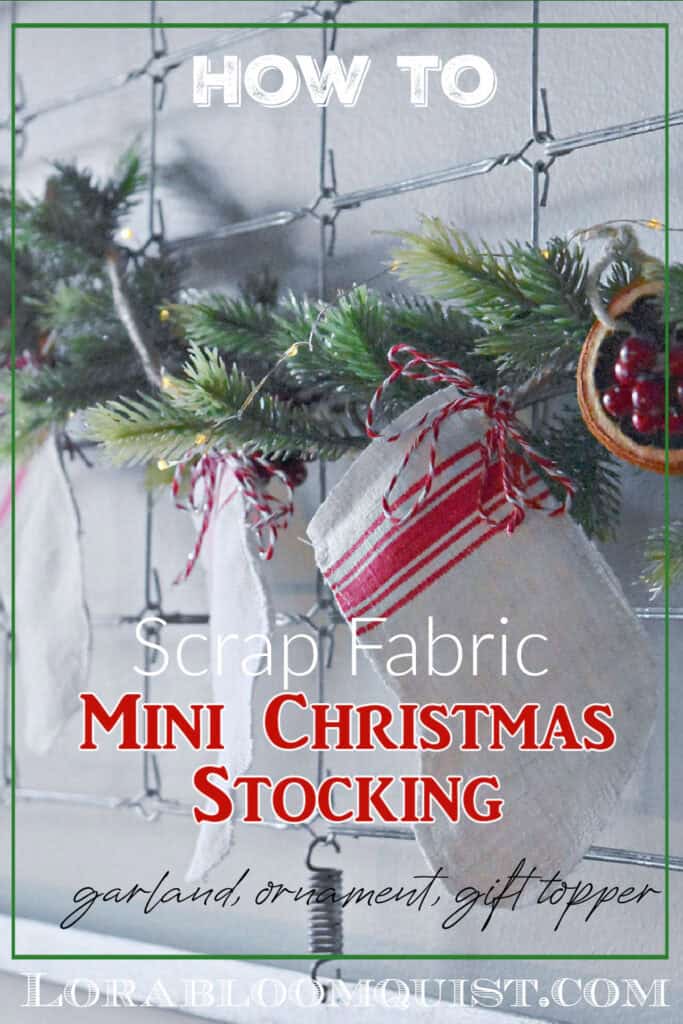 Handcrafted scrap fabric mini Christmas stocking hanging on evergreen garland.