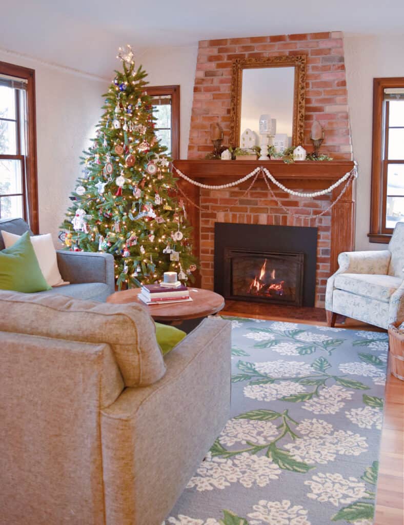 Christmas decorated living room with brick hearth.