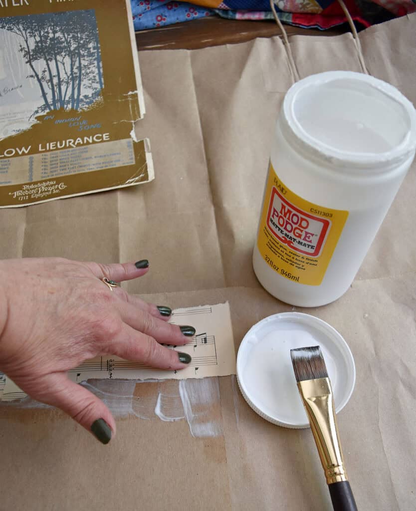 Crafting vintage sheet music into upcycled art with modge podge.