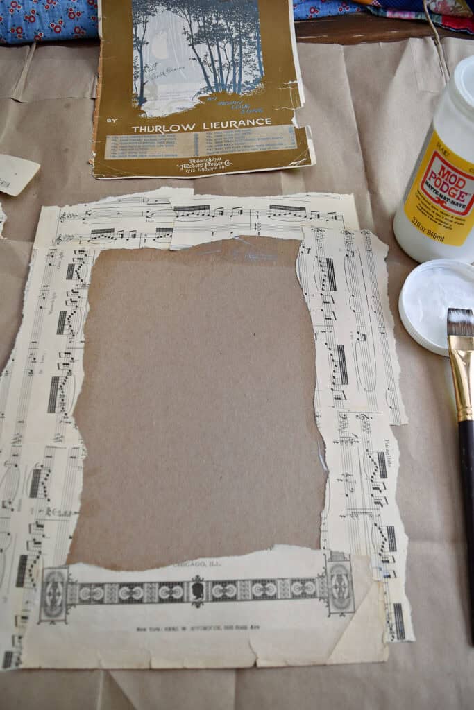 Crafting vintage sheet music into upcycled art with modge podge.