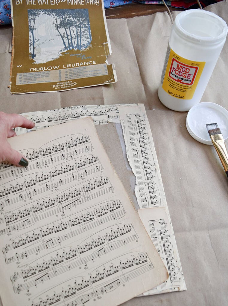 Crafting vintage sheet music into upcycled art with modge podge.