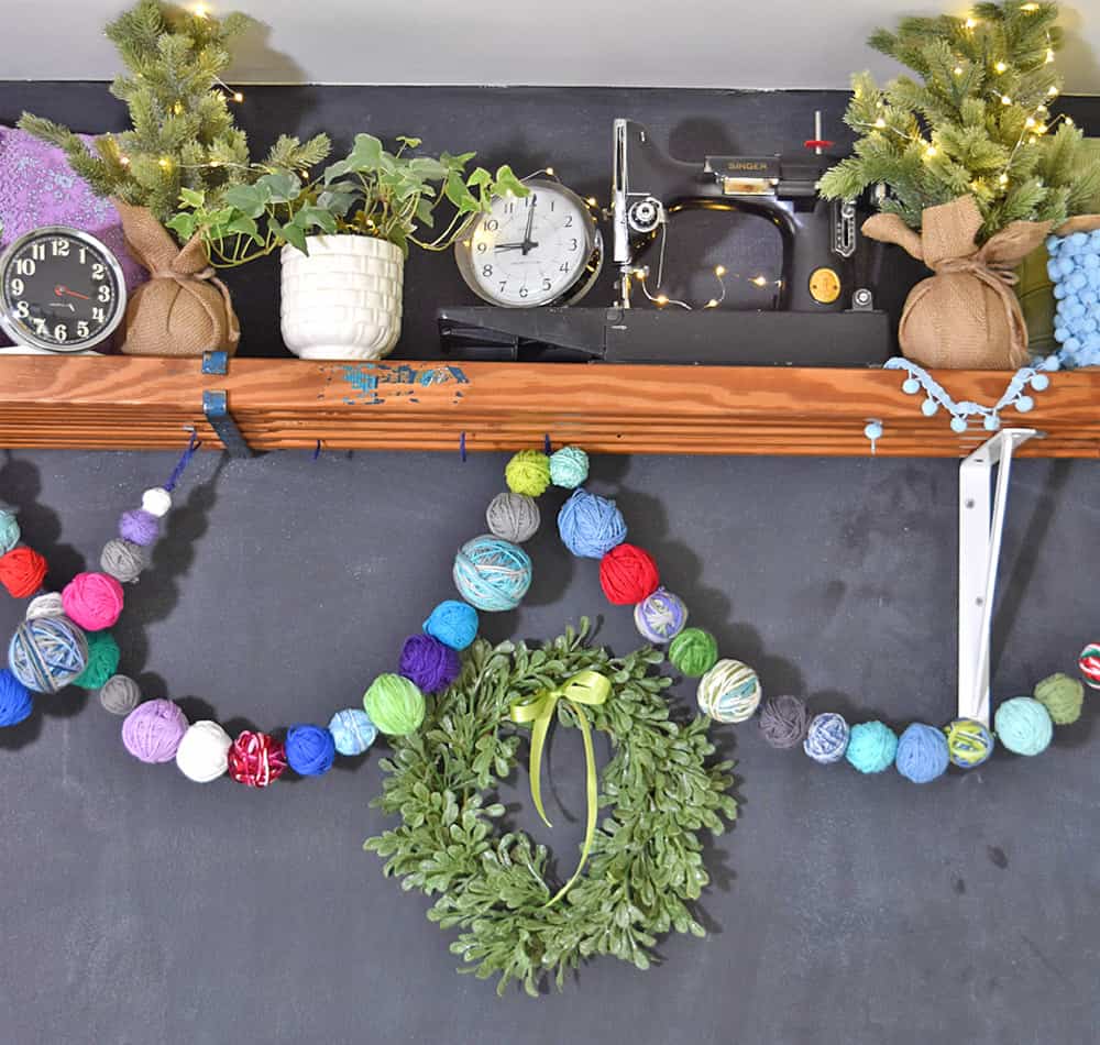 Yarn ball garland made to decorate a craft room display shelf