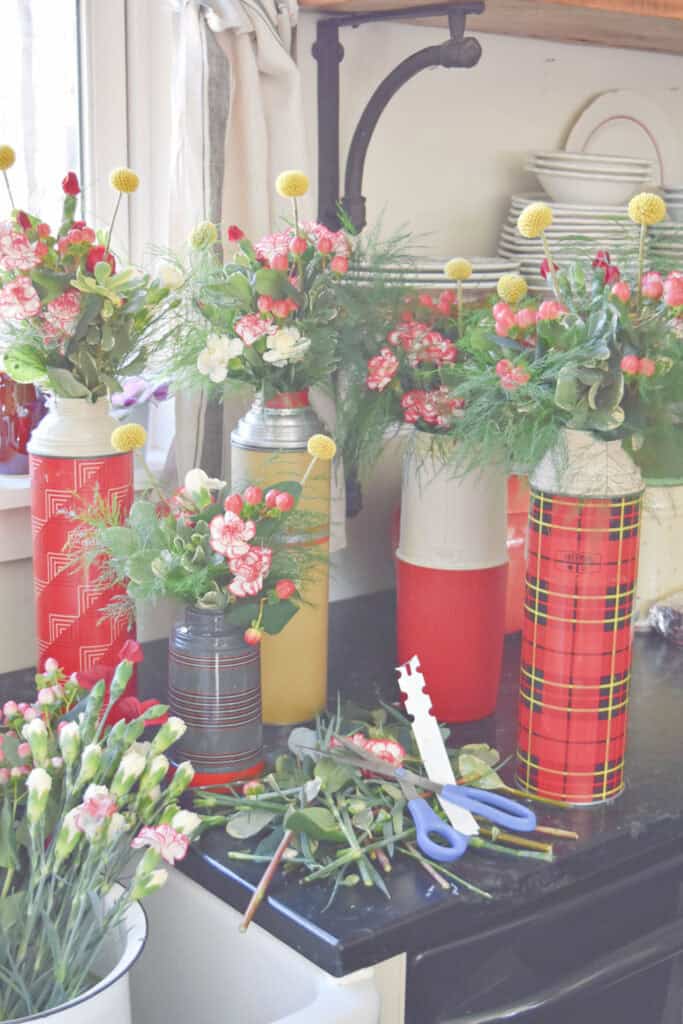 Vintage red thermoses and fresh flowers.