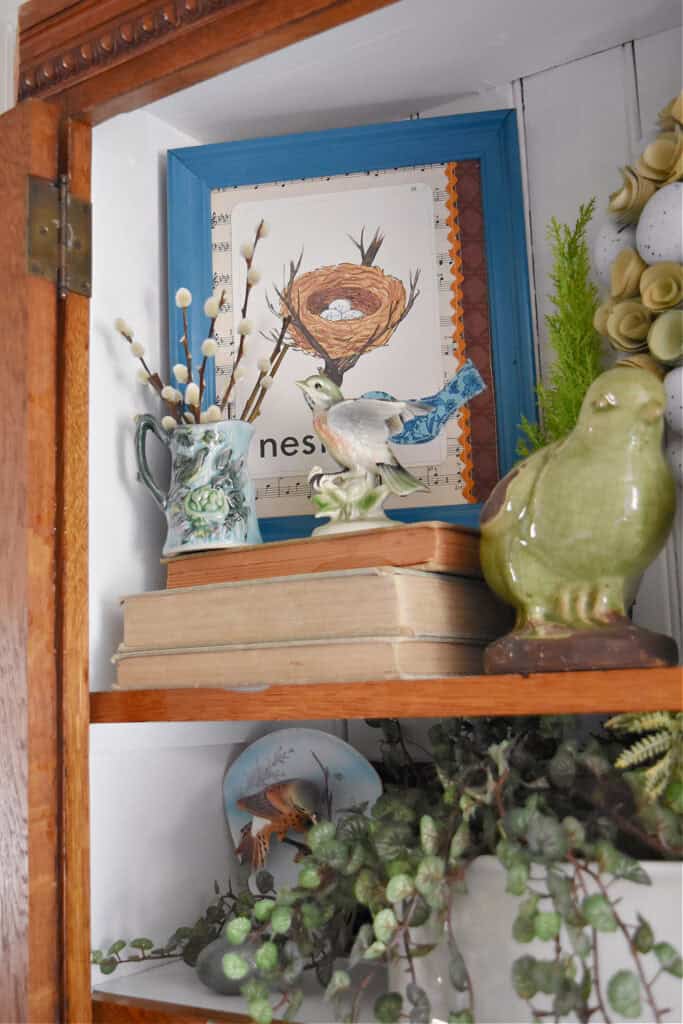 Bird themed vintage vignette in bookshelf.