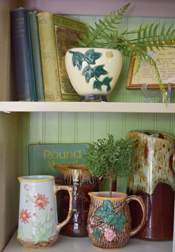 Vintage pitcher collection on shelf.