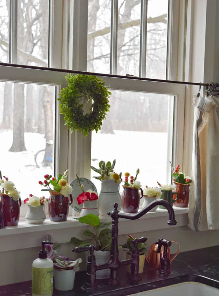 Windowsill display of vintage restaurant ware creamers and pitchers.