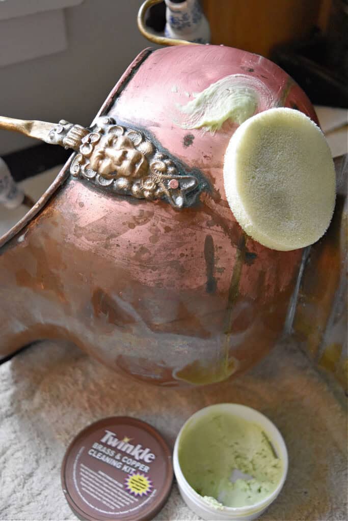 Polishing old copper coal scuttle.