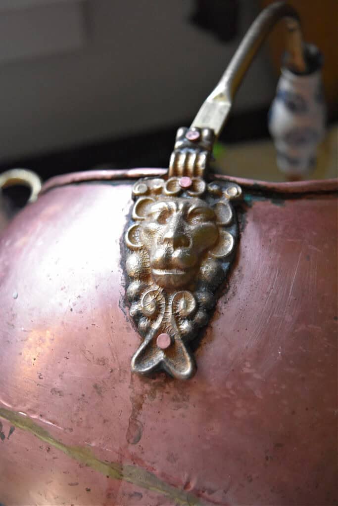 Brass lion handle on vintage copper.