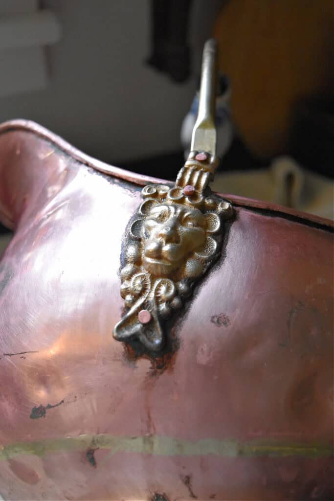 Brass lion handle on vintage copper.