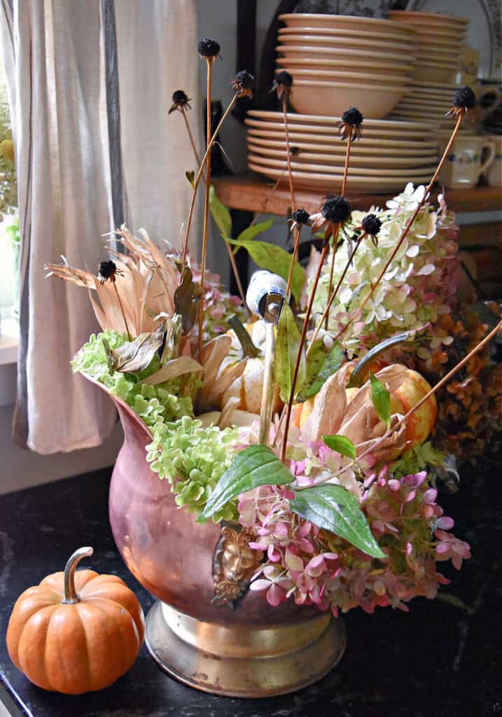 Fall naturals floral arrangement in copper coal scuttle.