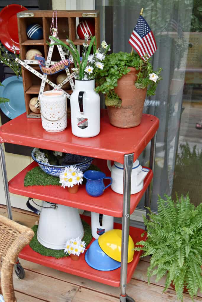 Vintage enamelware on red costco cart as summer Patriotic porch decor.