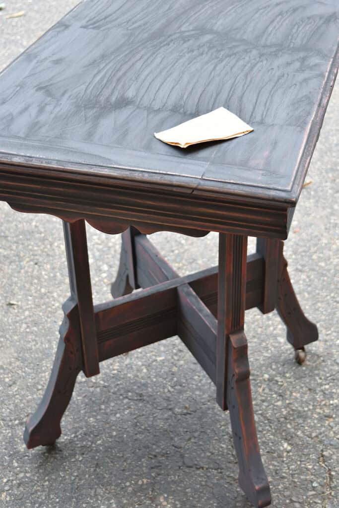 Sanding black milk paint on vintage side table.