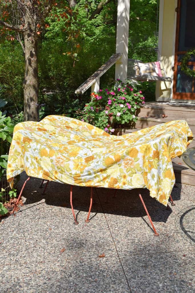 Vintage yellow floral coverlet drying in sun.