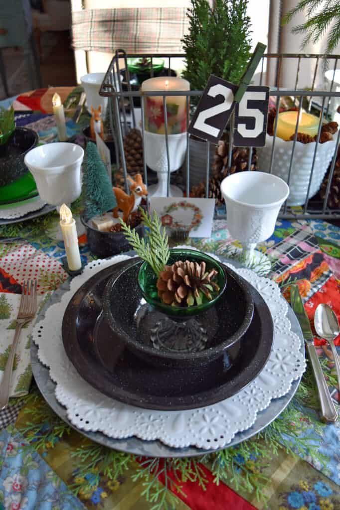 Christmas table setting with vintage quilt tablecloth and woodsy style.