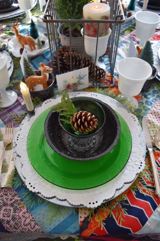 Christmas table setting with vintage quilt and woodland theme.