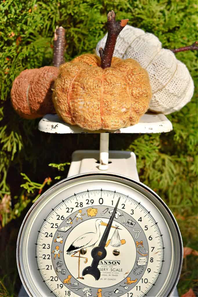 Fabric pumpkins on vintage baby scale.