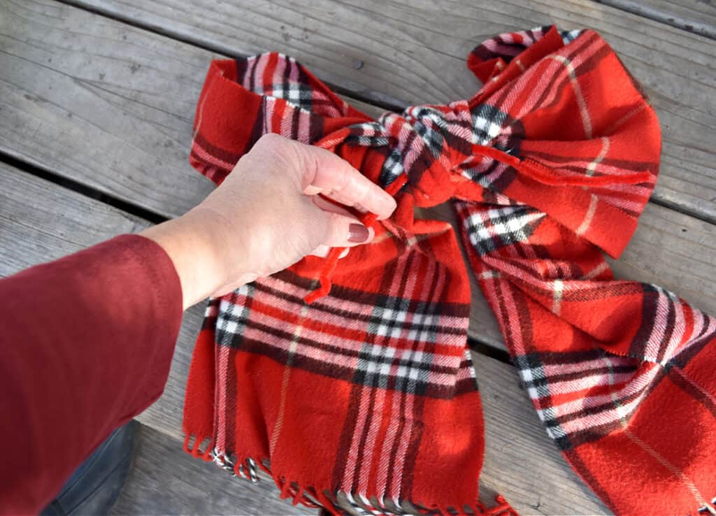 Red plaid scarf as decorative bow.