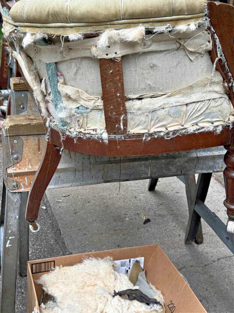 Ripping fabric off an antique settee.