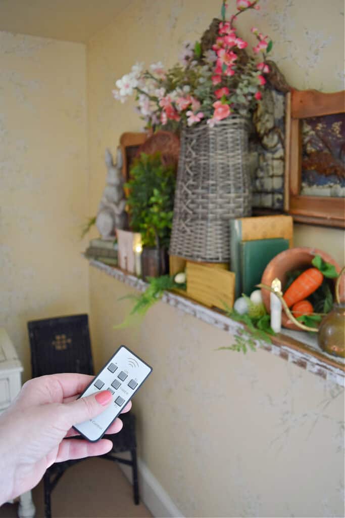 Remote control for candles on Spring decorated shelf.