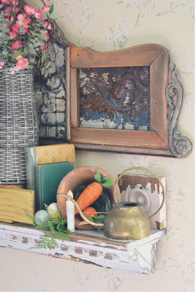 Brass watering can on Spring decorated shelf with vintage finds.