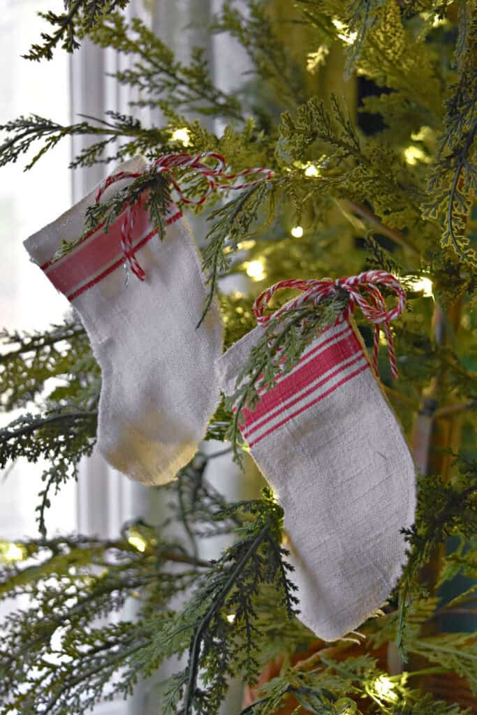 Handcrafted scrap fabric mini Christmas stockings hanging on tree.