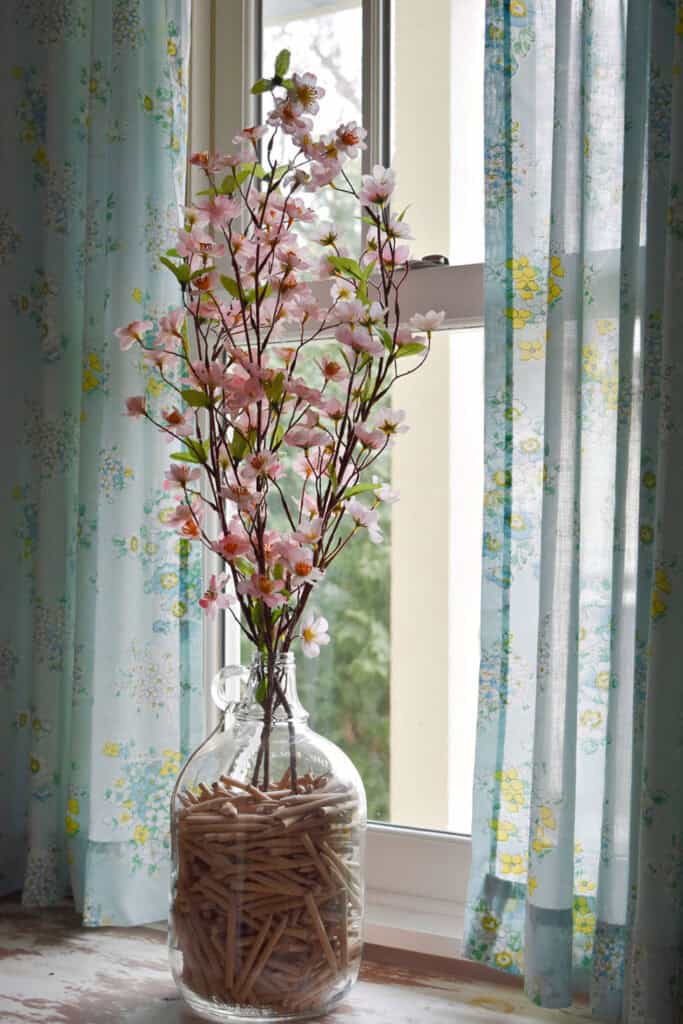 Flowering apple blossom branches in glass jug as Spring decor.